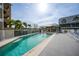 Community pool with a pavilion, lounge chairs, and tropical plants at 1960 Oregon Trl # 2B, Englewood, FL 34224
