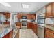 Kitchen with stainless steel appliances, granite countertops, tile flooring, and wooden cabinetry at 23239 Stelling Ave, Punta Gorda, FL 33980