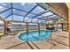 View of a screened-in pool area with a lounge chair and outdoor grill at 23239 Stelling Ave, Punta Gorda, FL 33980