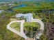 Beautiful aerial view of the home with circular driveway and waterway in the background at 27320 Egret Pl, Punta Gorda, FL 33983