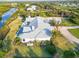 Aerial view of a luxury home with a sprawling lawn, bordered by a dark, wrought iron fence at 27320 Egret Pl, Punta Gorda, FL 33983