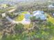 Lovely aerial view of home with large circular driveway, three-car garage and fenced play area at 27320 Egret Pl, Punta Gorda, FL 33983
