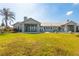 Spacious backyard featuring a well-maintained lawn, covered patio, and comfortable seating, perfect for relaxation at 27320 Egret Pl, Punta Gorda, FL 33983