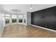 Spacious bedroom with a large window bay, dark accent wall, and sleek hardwood flooring at 27320 Egret Pl, Punta Gorda, FL 33983