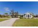 Beautifully landscaped home with mature landscaping, lush green grass, and an asphalt driveway at 27320 Egret Pl, Punta Gorda, FL 33983