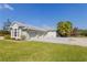 Charming light-green home featuring a metal roof, three-car garage, and lush green lawn with a play set at 27320 Egret Pl, Punta Gorda, FL 33983