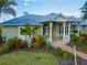 Charming front porch with brick pavers, white columns, and lush landscaping around the home at 27320 Egret Pl, Punta Gorda, FL 33983