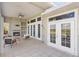 Beautiful outdoor patio with fireplace, comfortable seating, ceiling fan, and multiple doors to home at 27320 Egret Pl, Punta Gorda, FL 33983