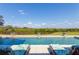 Beautiful backyard swimming pool with two lounge chairs and fountain features, perfect for relaxation and recreation at 27320 Egret Pl, Punta Gorda, FL 33983