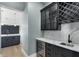 Modern wet bar with dark cabinetry, wine fridge, wine rack, sink, and stunning marble countertops at 27320 Egret Pl, Punta Gorda, FL 33983