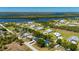 Aerial view of a charming home featuring a pool, lush landscaping, and picturesque waterfront surroundings at 28482 Coco Palm Dr, Punta Gorda, FL 33982