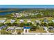 An aerial view showcasing the property with a striking blue roof amidst lush landscaping and surrounding neighborhood and water views at 28482 Coco Palm Dr, Punta Gorda, FL 33982