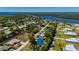 Aerial view of a charming home featuring a pool, lush landscaping, and picturesque waterfront surroundings at 28482 Coco Palm Dr, Punta Gorda, FL 33982