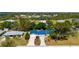 Aerial view of a home with a blue roof nestled in a well-developed community with mature trees at 28482 Coco Palm Dr, Punta Gorda, FL 33982