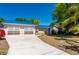 Single-story home with a blue roof and mature landscaping in a lush green setting at 28482 Coco Palm Dr, Punta Gorda, FL 33982