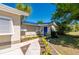Inviting front entrance featuring a blue door, decorative shutters, a quaint walkway, and lush tropical landscaping at 28482 Coco Palm Dr, Punta Gorda, FL 33982