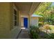 A front entrance features garden art and a pathway to the bright blue front door at 28482 Coco Palm Dr, Punta Gorda, FL 33982