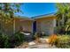 A well-maintained front entrance features garden art and a pathway to the bright blue front door at 28482 Coco Palm Dr, Punta Gorda, FL 33982