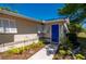 Beautifully landscaped front entrance featuring a blue door and charming white shutters, adding curb appeal at 28482 Coco Palm Dr, Punta Gorda, FL 33982