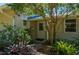 Charming front entrance with lush landscaping and a covered porch area with a door at 28482 Coco Palm Dr, Punta Gorda, FL 33982