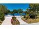 Charming home with a blue metal roof, front yard flowers, an extra-long concrete driveway and lush landscaping at 28482 Coco Palm Dr, Punta Gorda, FL 33982