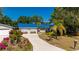 Charming home with a blue metal roof, front yard flowers, an extra-long concrete driveway and lush landscaping at 28482 Coco Palm Dr, Punta Gorda, FL 33982