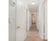 Hallway with tiled floor, white walls, and multiple doors offering access to different areas at 28482 Coco Palm Dr, Punta Gorda, FL 33982