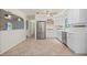 Renovated kitchen features stainless steel appliances, white cabinetry, and is open to the living area through arched opening at 28482 Coco Palm Dr, Punta Gorda, FL 33982