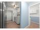 Functional laundry room with modern appliances, open shelving, and tile flooring at 28482 Coco Palm Dr, Punta Gorda, FL 33982