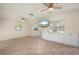 Spacious living room with tile floors, built-in cabinets, ceiling fans, and ample natural light from the windows at 28482 Coco Palm Dr, Punta Gorda, FL 33982