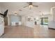Bright and open living room with tile flooring, ceiling fans, modern lighting, and an open layout to the kitchen at 28482 Coco Palm Dr, Punta Gorda, FL 33982