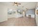 Bright living room featuring tile floors, built-in cabinets, a ceiling fan, and a large TV for entertainment at 28482 Coco Palm Dr, Punta Gorda, FL 33982
