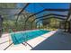 An inviting in-ground pool encased in a screened enclosure, surrounded by lush landscaping at 28482 Coco Palm Dr, Punta Gorda, FL 33982