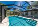 In-ground swimming pool featuring a screened enclosure and a sunny outdoor space at 28482 Coco Palm Dr, Punta Gorda, FL 33982