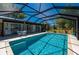 A beautiful in-ground swimming pool surrounded by lush landscaping and screened enclosure at 28482 Coco Palm Dr, Punta Gorda, FL 33982