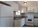 A cozy kitchen featuring white cabinets, modern appliances, and stone countertops at 351 S Mccall Rd, Englewood, FL 34223