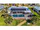 An aerial shot showcases a screened pool, patio, and solar panels on the roof of this beautiful house at 529 Belvedere Ct, Punta Gorda, FL 33950