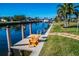 Waterfront property with a private boat dock and canal access, featuring two wooden Adirondack chairs at 529 Belvedere Ct, Punta Gorda, FL 33950