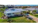 Exterior view of a charming home, featuring a manicured lawn, palm trees, and a brick driveway at 529 Belvedere Ct, Punta Gorda, FL 33950