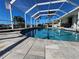 Sparkling pool with brick trim inside a screened-in lanai with palms at 529 Belvedere Ct, Punta Gorda, FL 33950