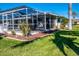 View of the patio, pool, and yard from the side of a screened-in outdoor living area at 529 Belvedere Ct, Punta Gorda, FL 33950