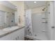 Bathroom featuring a tile shower, neutral-toned vanity, and a mirror with modern lighting at 7393 West Lenox Cir, Punta Gorda, FL 33950