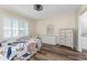 Bright bedroom with a floral bedspread, white shutters, and matching dressers on hardwood flooring at 7393 West Lenox Cir, Punta Gorda, FL 33950