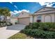 Charming exterior features lush landscaping, neutral color palette, and a two-car garage at 7393 West Lenox Cir, Punta Gorda, FL 33950