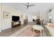 Open-concept living room with hardwood floors, ceiling fan, and ample natural light at 7393 West Lenox Cir, Punta Gorda, FL 33950