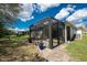 Exterior view of screened-in porch with patio furniture and a view of the green backyard at 7393 West Lenox Cir, Punta Gorda, FL 33950