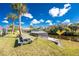 Lush waterfront backyard with a screened lanai, picnic table and tropical landscaping for outdoor enjoyment at 1052 Eppinger Dr, Port Charlotte, FL 33953
