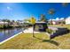 Beautiful waterfront backyard featuring a screened lanai with ample space for entertaining at 1052 Eppinger Dr, Port Charlotte, FL 33953