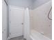Neutral-tiled bathroom featuring a bathtub with a white shower curtain and wood-look vinyl flooring at 1052 Eppinger Dr, Port Charlotte, FL 33953