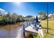 Waterfront home with a private dock featuring a boat lift and covered seating area perfect for relaxing by the water at 1052 Eppinger Dr, Port Charlotte, FL 33953